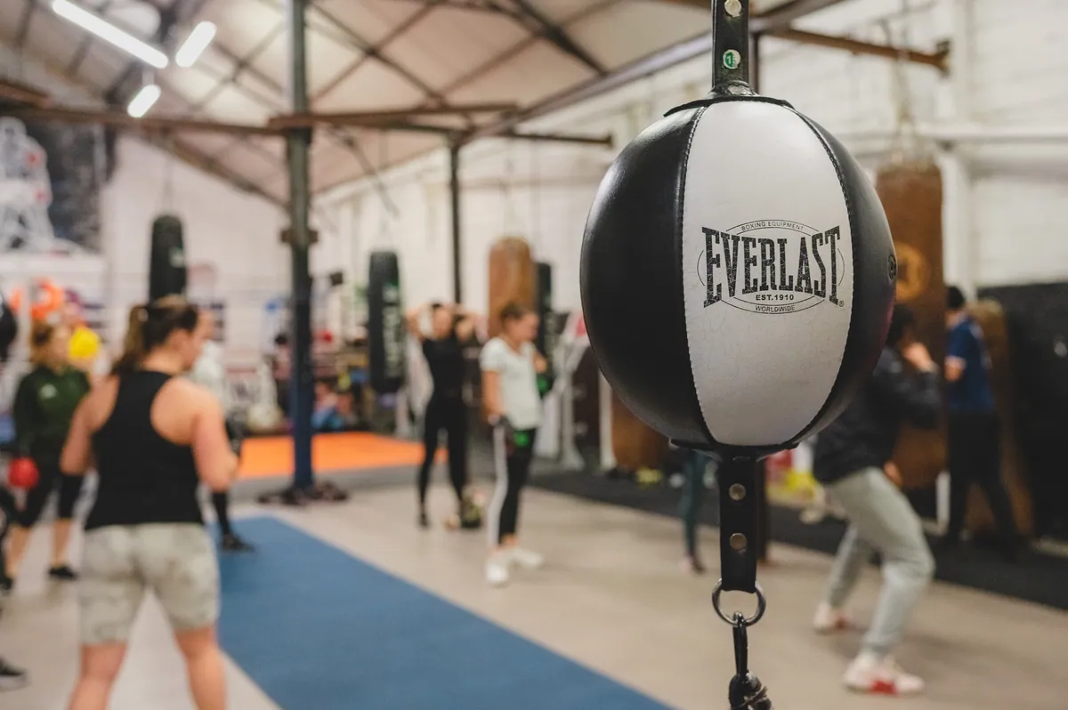 Cours de cardio boxing sans opposition : le groupe enchaîne les combinaisons au rythme du minuteur — Boxing Center, Toulouse.