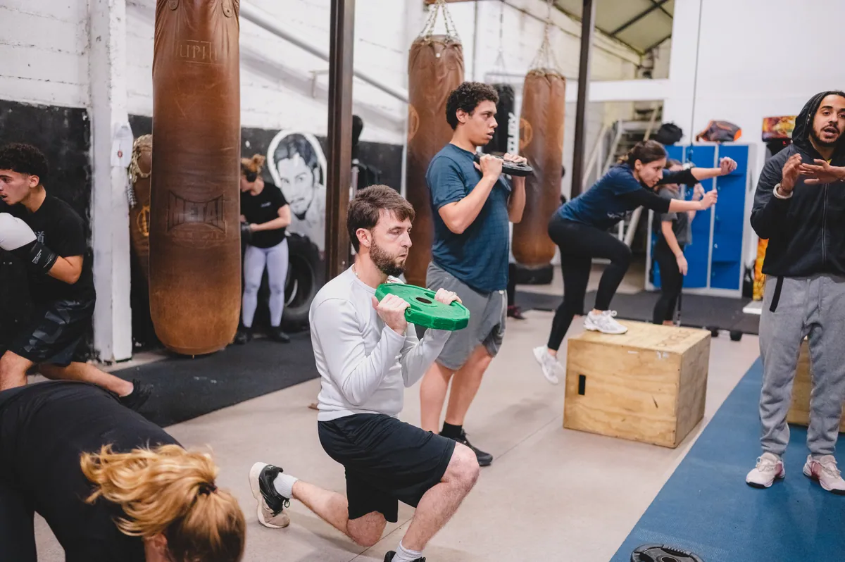 Groupe en préparation physique : sauts sur box en bois entre les sacs de frappe