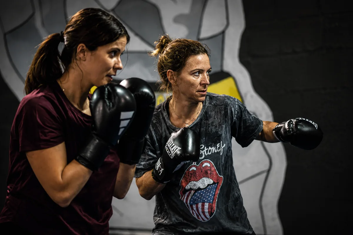 Deux pratiquantes du cours Boxing Lady, gants aux poings, en garde face à face